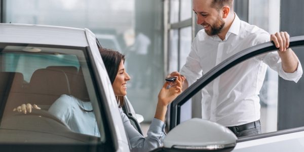 Salesman and woman looking for a car in a car showroom